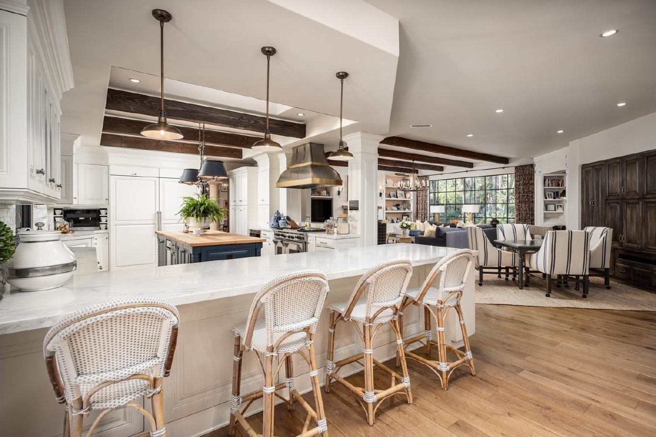 White kitchen with marble island and rattan counter stools at the Rancho Santa Fe residence