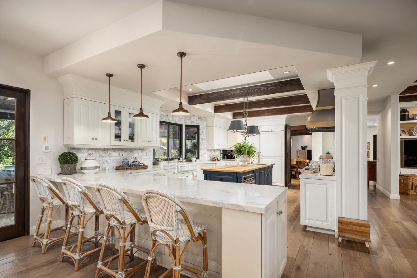 Kitchen island with brass pendants and wood beams