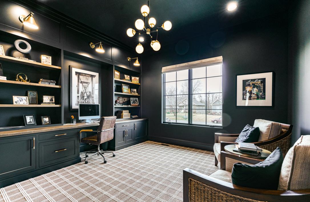 Dark green home office with brass sconces and built-ins